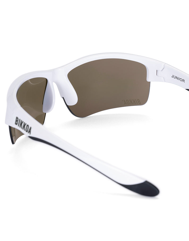 Gafas deportivas infantiles BIKKOA JUNIOR con montura blanca y lente azul REVO para protección solar y visión deportiva, detalle lateral de la patilla ligera y la lente azul REVO para protección solar y visión deportiva para uso infantil - Azul