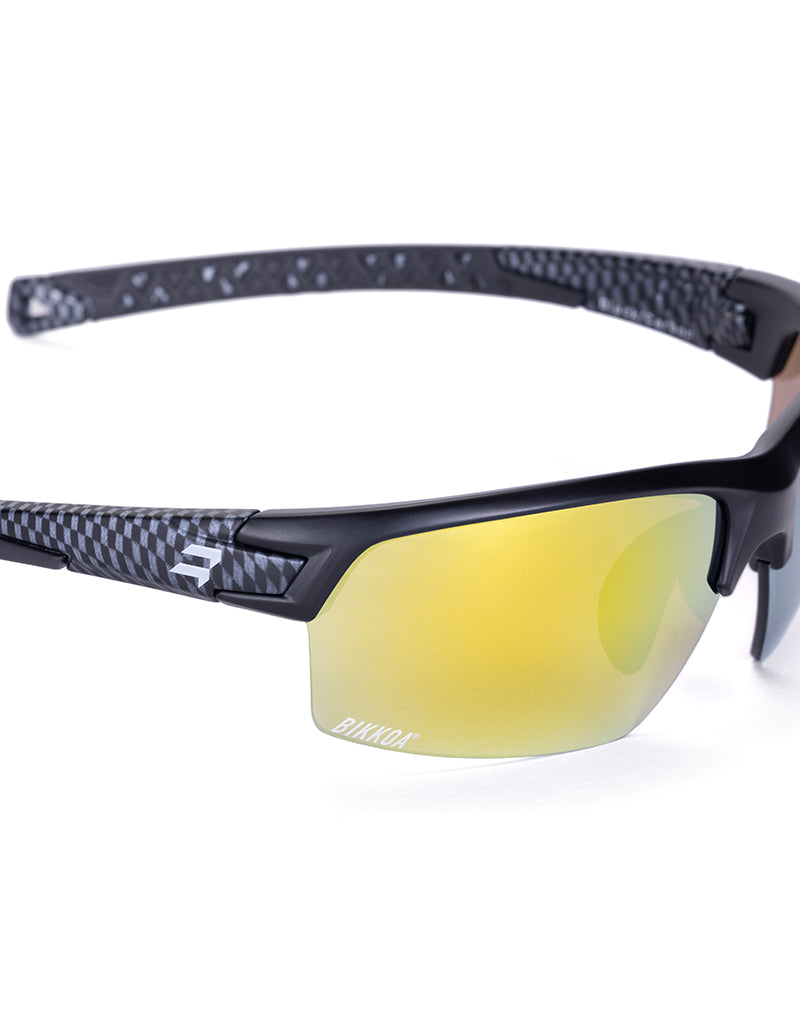 Gafas deportivas BIKKOA GOAT color dorada, detalle de la patilla flexible TR90 y la lente dorada REVO en configuración doble - Dorada