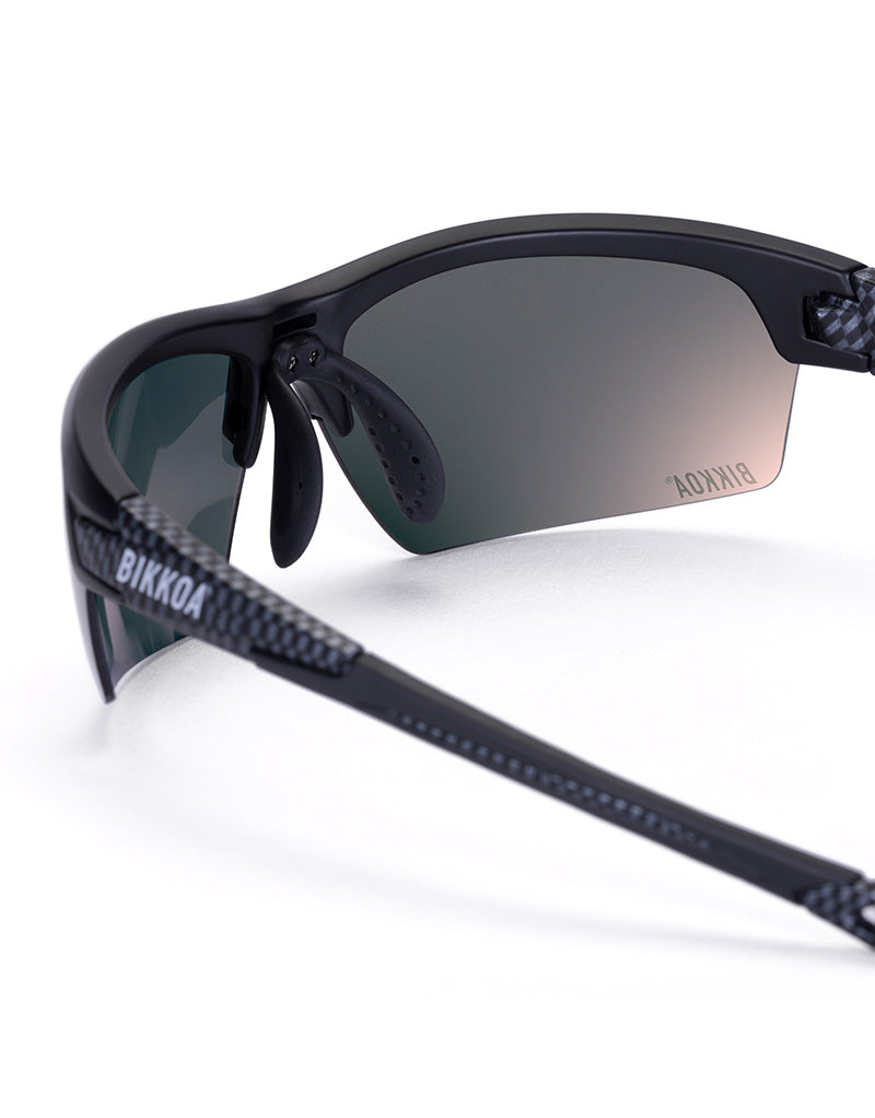 Gafas deportivas BIKKOA GOAT color violeta, detalle de la patilla flexible TR90 y la lente violeta REVO en configuración doble - Violeta