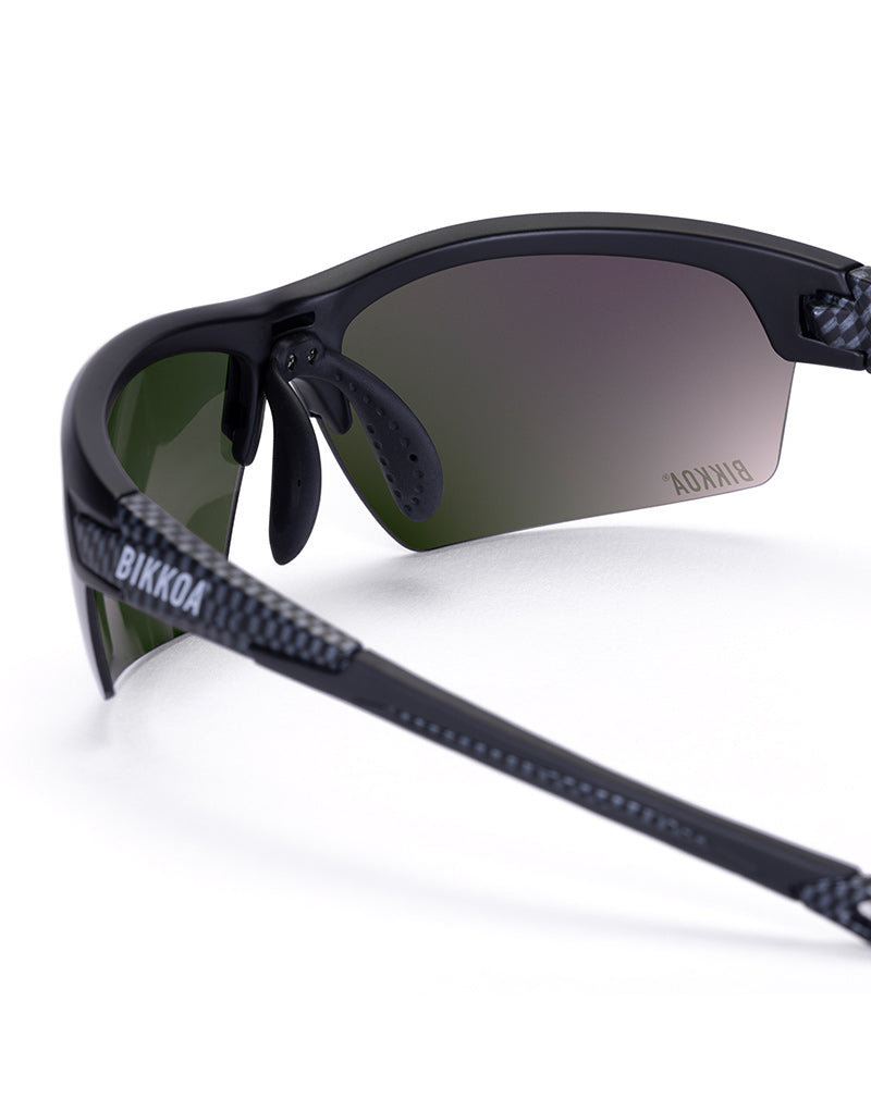 Gafas deportivas BIKKOA GOAT color verde, detalle de la patilla flexible TR90 y la lente verde REVO en configuración doble - Verde