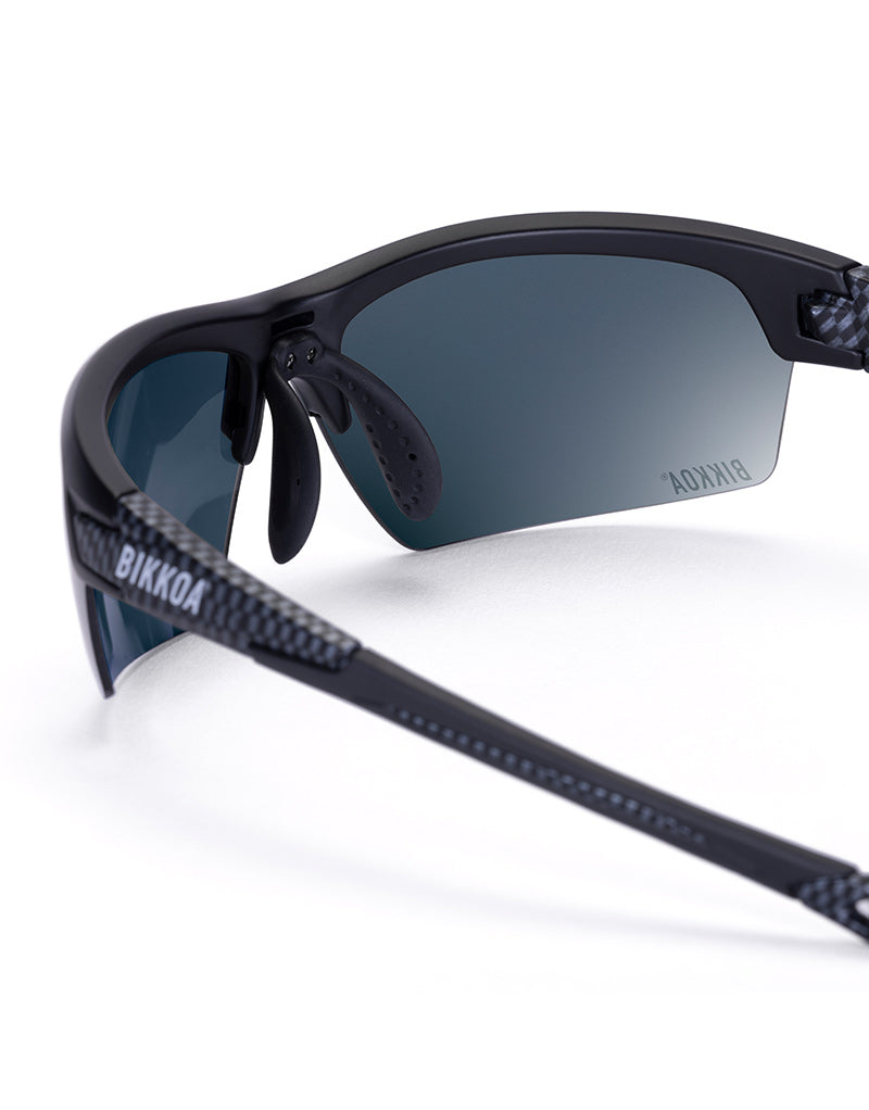 Gafas deportivas BIKKOA GOAT color azul, detalle de la patilla flexible TR90 y la lente azul REVO en configuración doble - Azul