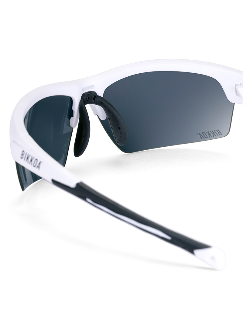 Gafas deportivas BIKKOA LAB con montura blanca mate y lente azul REVO, detalle de la patilla TR90 blanca mate y la lente azul REVO en sistema de doble lente - Azul