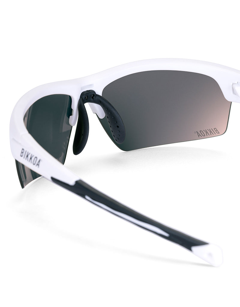 Gafas deportivas BIKKOA LAB con montura blanca mate y lente violeta REVO, detalle de la patilla TR90 blanca mate y la lente violeta REVO en sistema de doble lente - Violeta