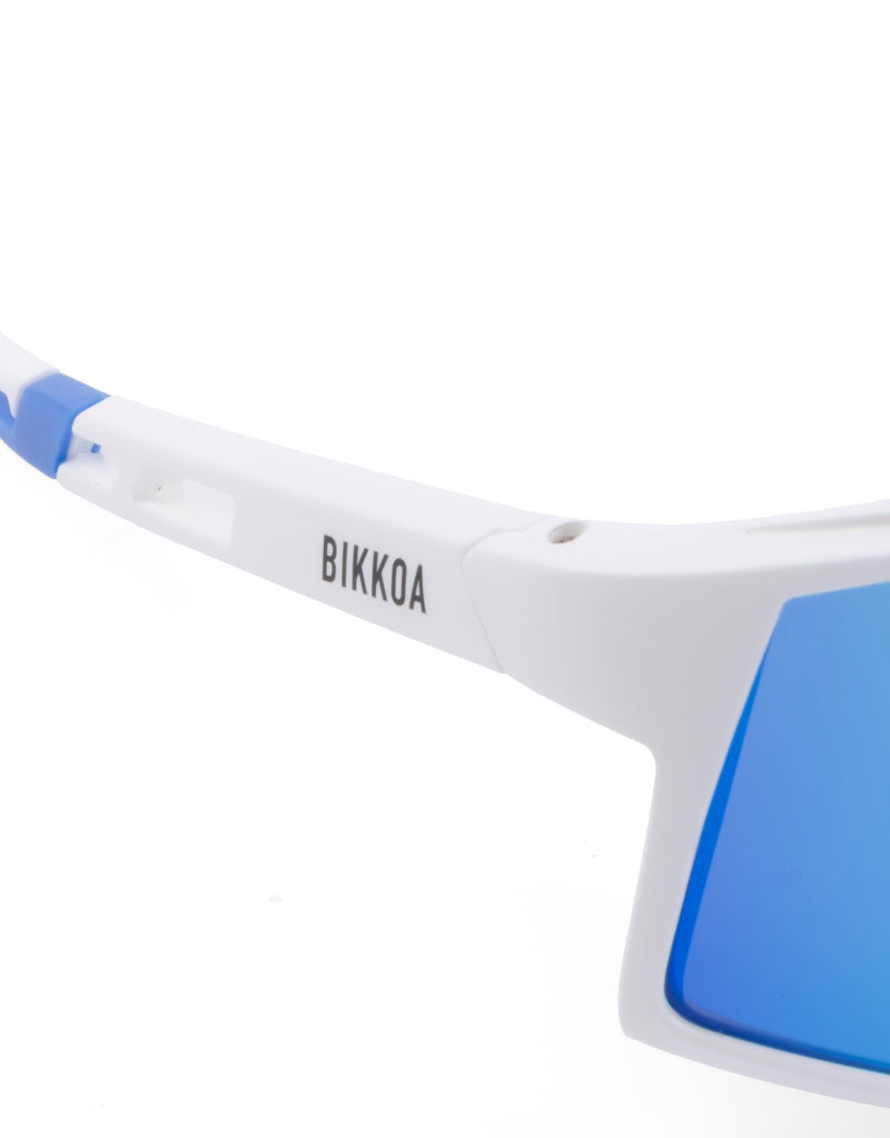 Detalle de lente azul y montura blanca en gafas deportivas infantiles BIKKOA VARYS - Azul