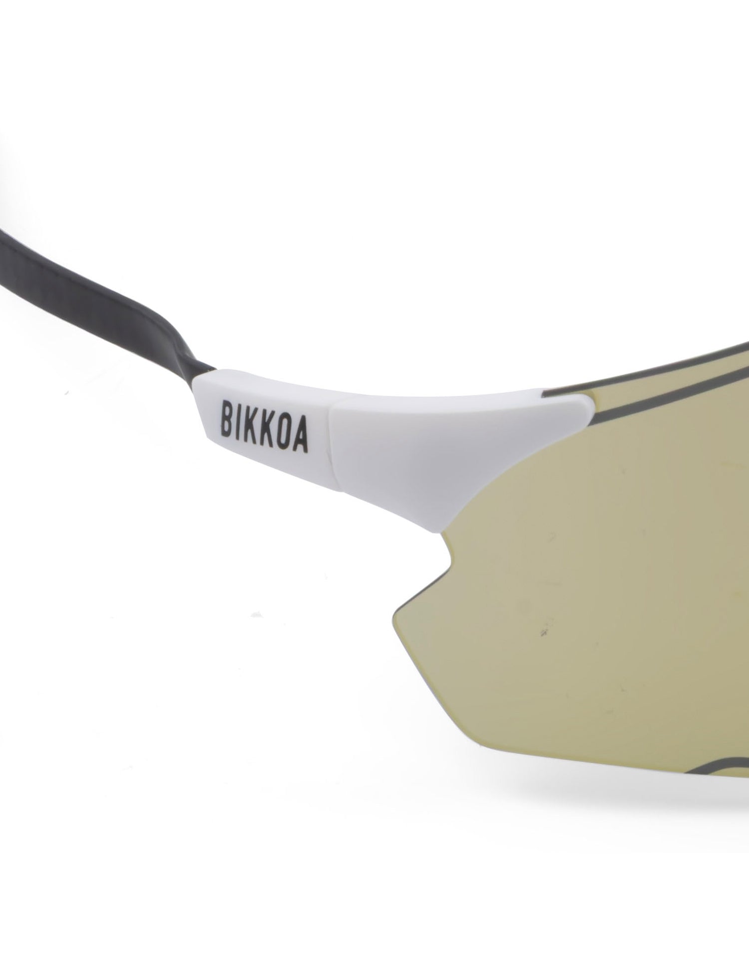 Detalle de la lente dorada y patilla de carbono en las gafas BIKKOA EXON - Dorada