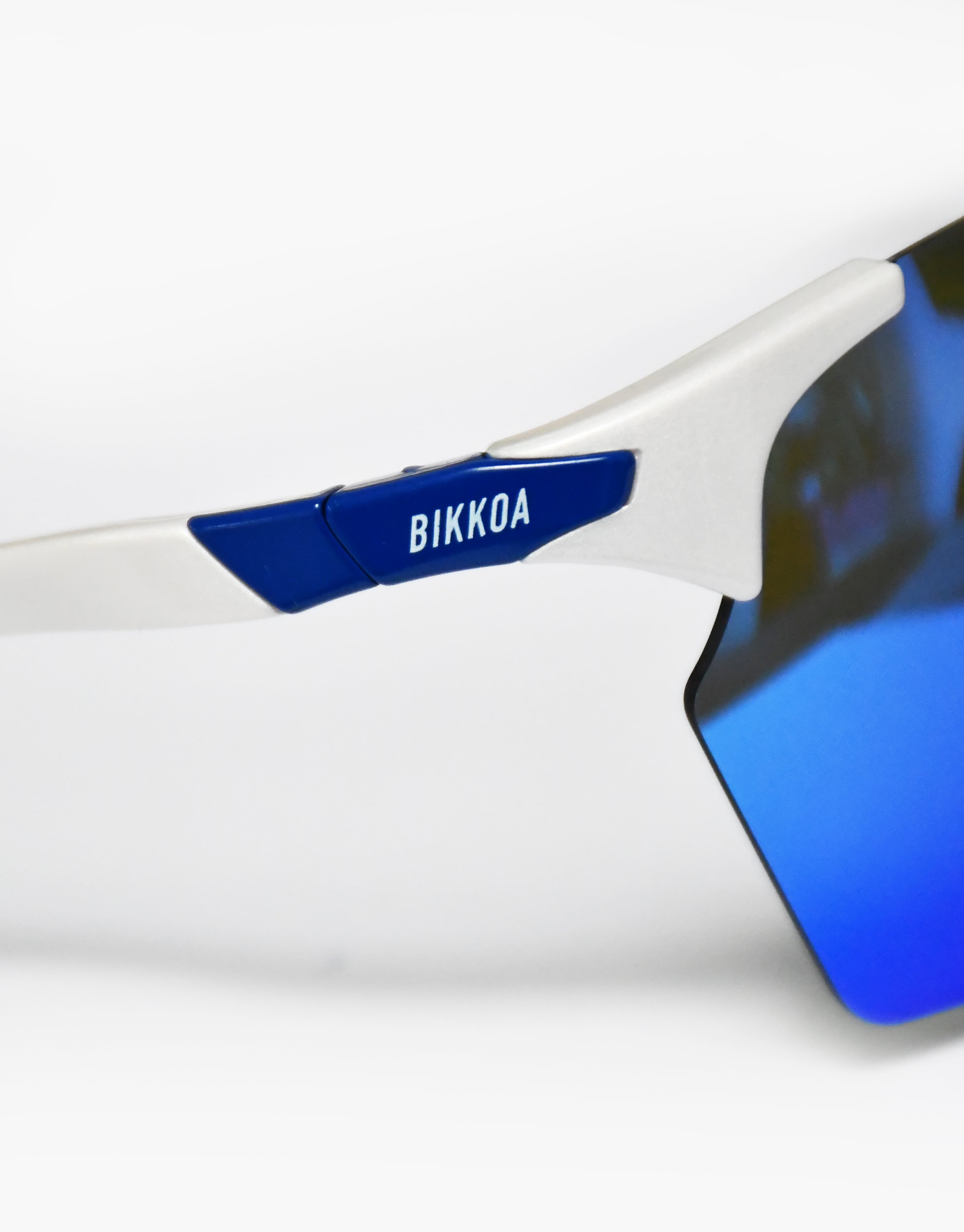Gafas deportivas polarizadas BIKKOA VYROX con lente azul polarizada y montura blanca deportiva, detalle técnico del acabado polarizado y soporte lateral del modelo VYROX - Azul